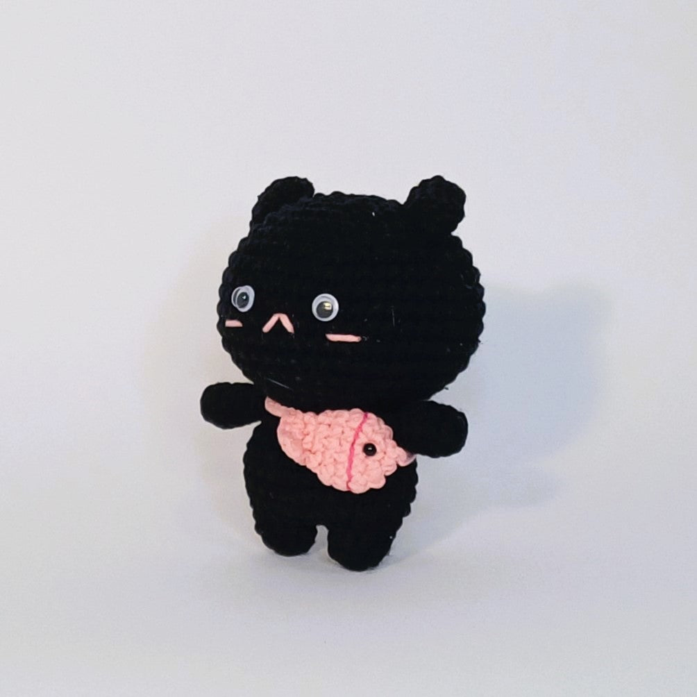Peluche au crochet du chat noir avec un sac à poisson